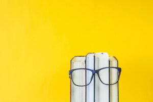 Books wearing glasses on yellow background